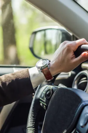 Man driving car, hand on steering wheel