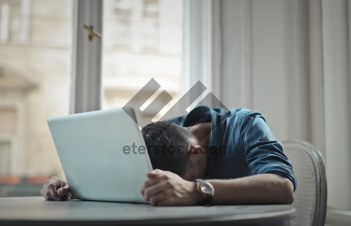 Picture of Happy businessman working on laptop in home office