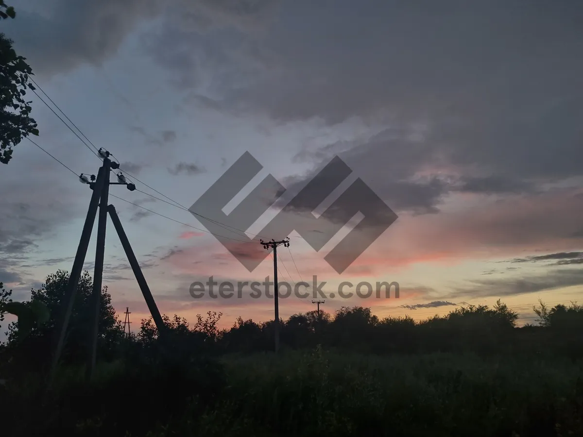 Picture of Silhouette energy tower against sunset landscape.