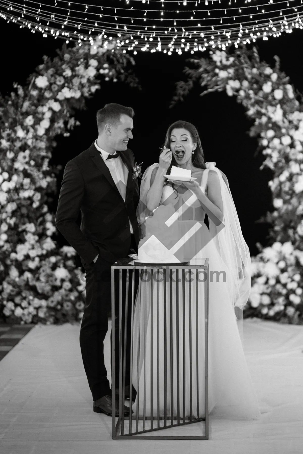 Picture of Happy couple in wedding attire with bouquet outdoors