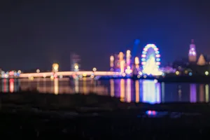 Urban skyline illuminated at night reflecting on water fountain