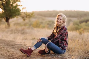 Happy woman in park wearing cowboy boots