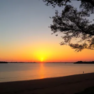 Tropical Sunset Reflection on Beach"
or
"Idyllic Coastal Sunset Silhouette