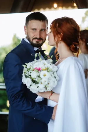 Happy newlywed couple outdoors smiling at their wedding