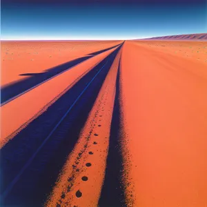 Sun-kissed Dunes: Majestic Desert Landscape under Orange Sky