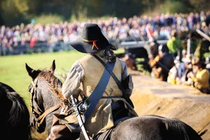 military horse trainer riding with gun outdoors