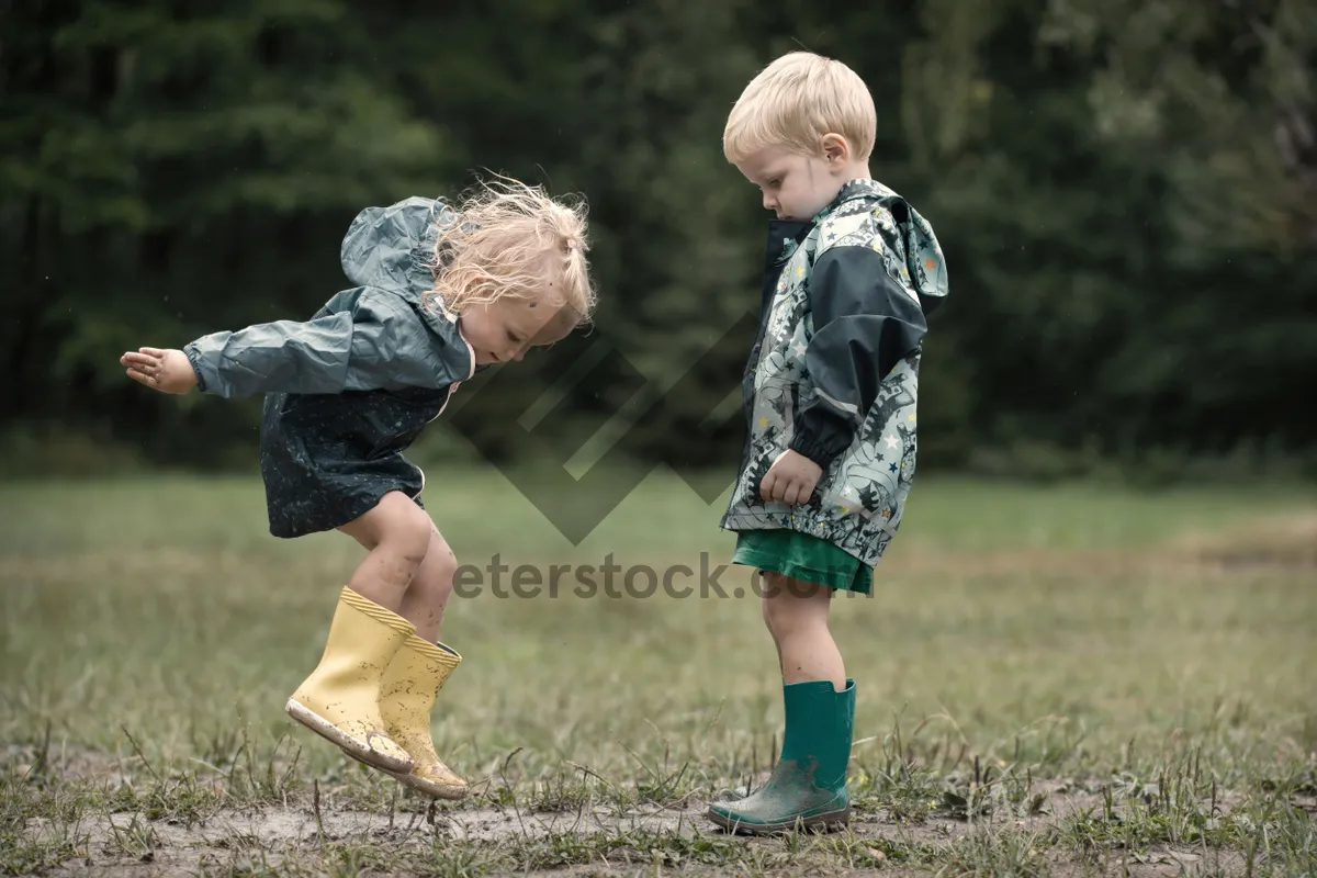 Picture of Happy blond boy playing with rugby ball in park.