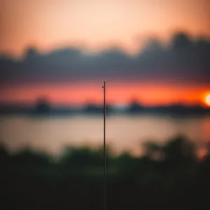 Golden Horizon: A Mesmerizing Sunset Over Fields and Turbine