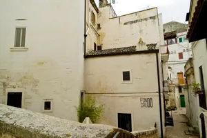 Medieval stone prison wall in ancient cityscape.