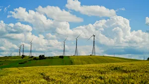 Summer sky over rural field with wind turbine