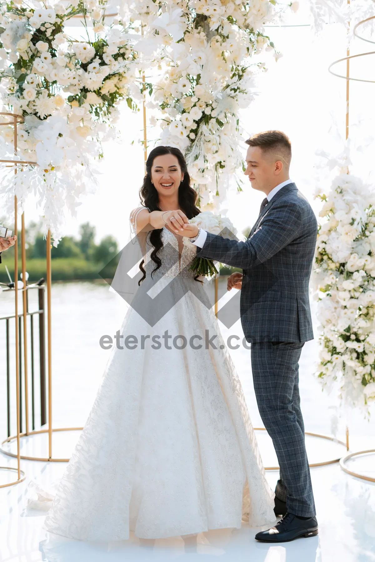 Picture of Happy groom and bride celebrate love outdoors with flowers