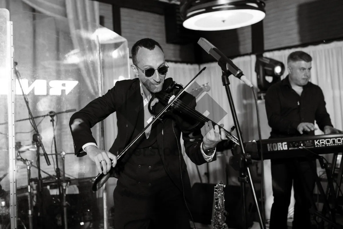 Picture of Rock musician performing with guitar and microphone on stage.