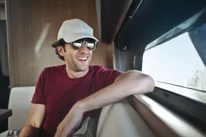 Happy man driving car with seat belt on.