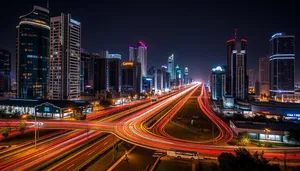 Modern city skyline at night with illuminated buildings.