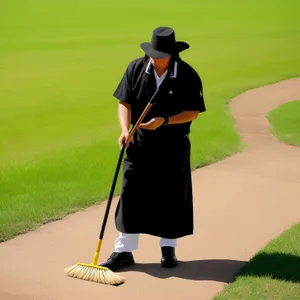 Active golfer swings club on green fairway.