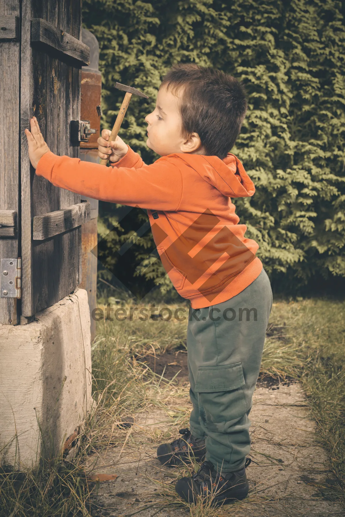 Picture of Happy boy playing with bow and arrow in park.