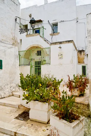 Historic stucco home with balcony and flowers.