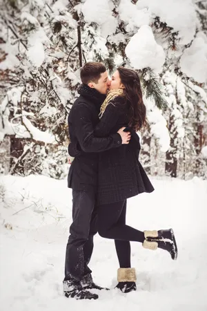 Happy man enjoying snowy winter season outdoors with snowshoe.