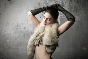 Fashion model in fur coat posing sensually