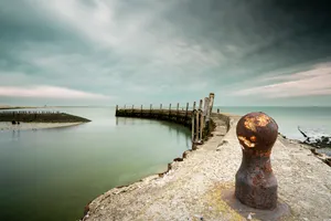 Scenic waterfront view with pier and clouds overhead