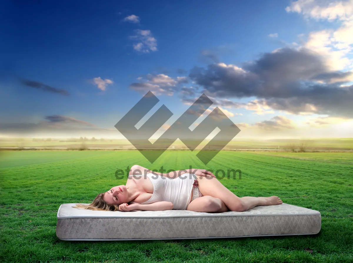 Picture of Attractive woman relaxing in the park on summer grass.