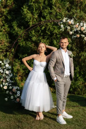 Happy Wedding Couple Outdoors with Bouquet of Flowers