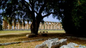 Ancient stone memorial in park cemetery landscape.