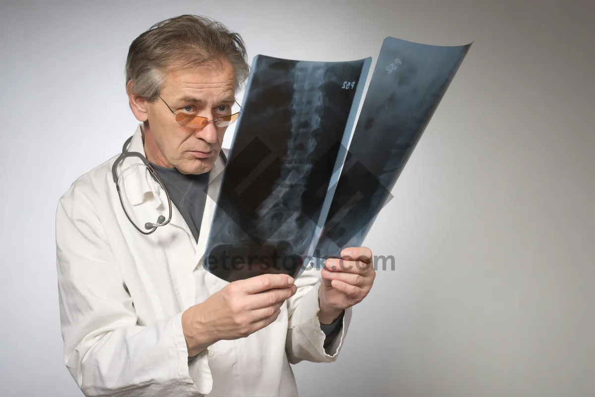 Picture of Professional male doctor in lab coat performing surgery.