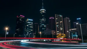 Modern city skyline at night with river reflection.