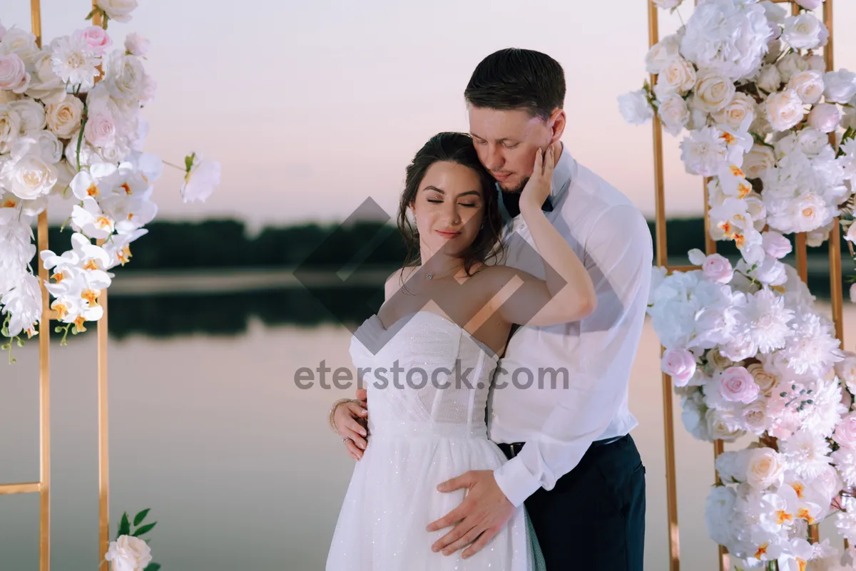 Picture of Happy couple celebrating their wedding day outdoors with flowers