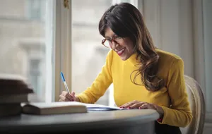 Happy businesswoman working on laptop in home office