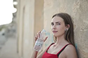 Attractive lady holding hair spray bottle with smile