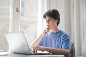 Happy businessman working on laptop at home office