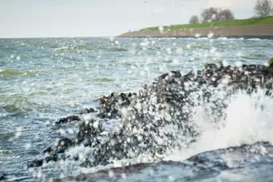 Rocky shore waves under sky