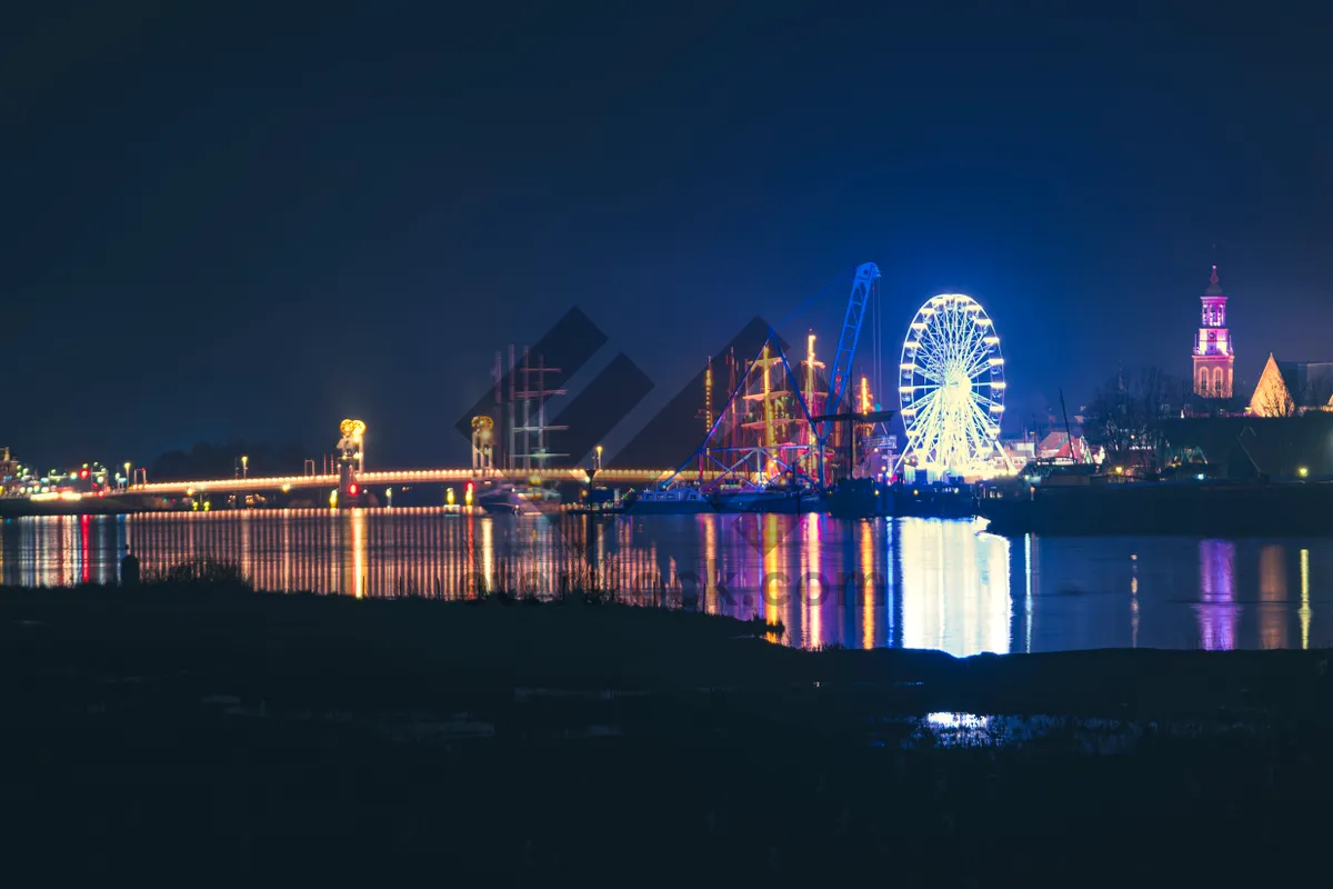 Picture of Modern city skyline at night with bridge reflection.