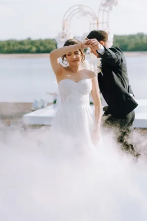 Happy couple in wedding attire holding flower bouquet