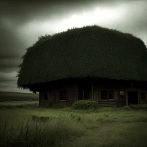 Tropical beach hut with thatch roof against scenic sky.