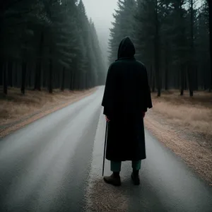 Black Cloak-Wearing Man Walking on a Journey