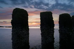 Sunset over ocean beach coast landscape structure