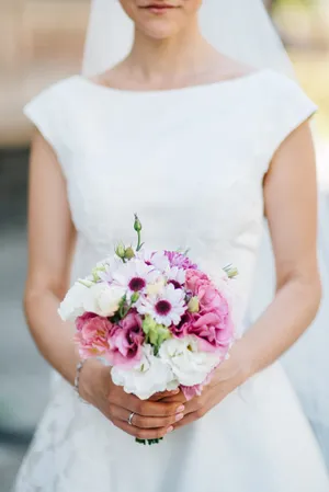 Happy bride in wedding dress holding bouquet