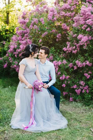 Happy bride and groom surrounded by flowers in garden.