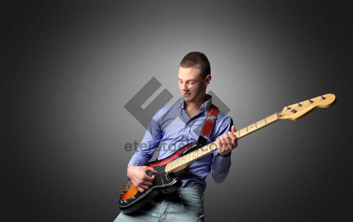 Picture of Rock musician playing electric guitar on stage concert.