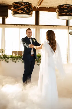 Happy couple celebrating wedding day with bouquet of flowers.