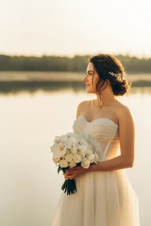 Gorgeous bride with bouquet smiling happily.