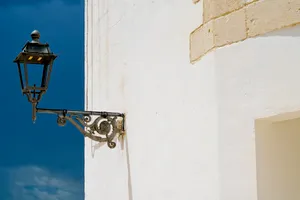 Old church tower with bell and stucco walls.