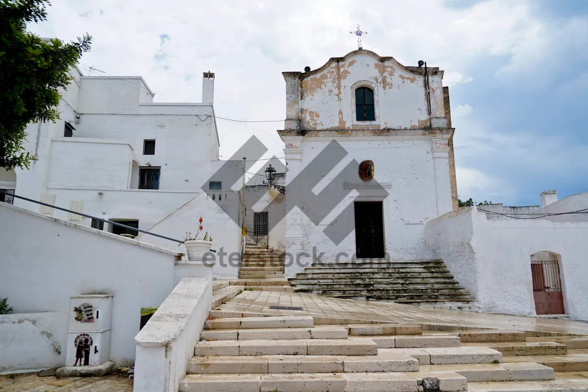 Picture of Historic church with bell tower against city skyline.