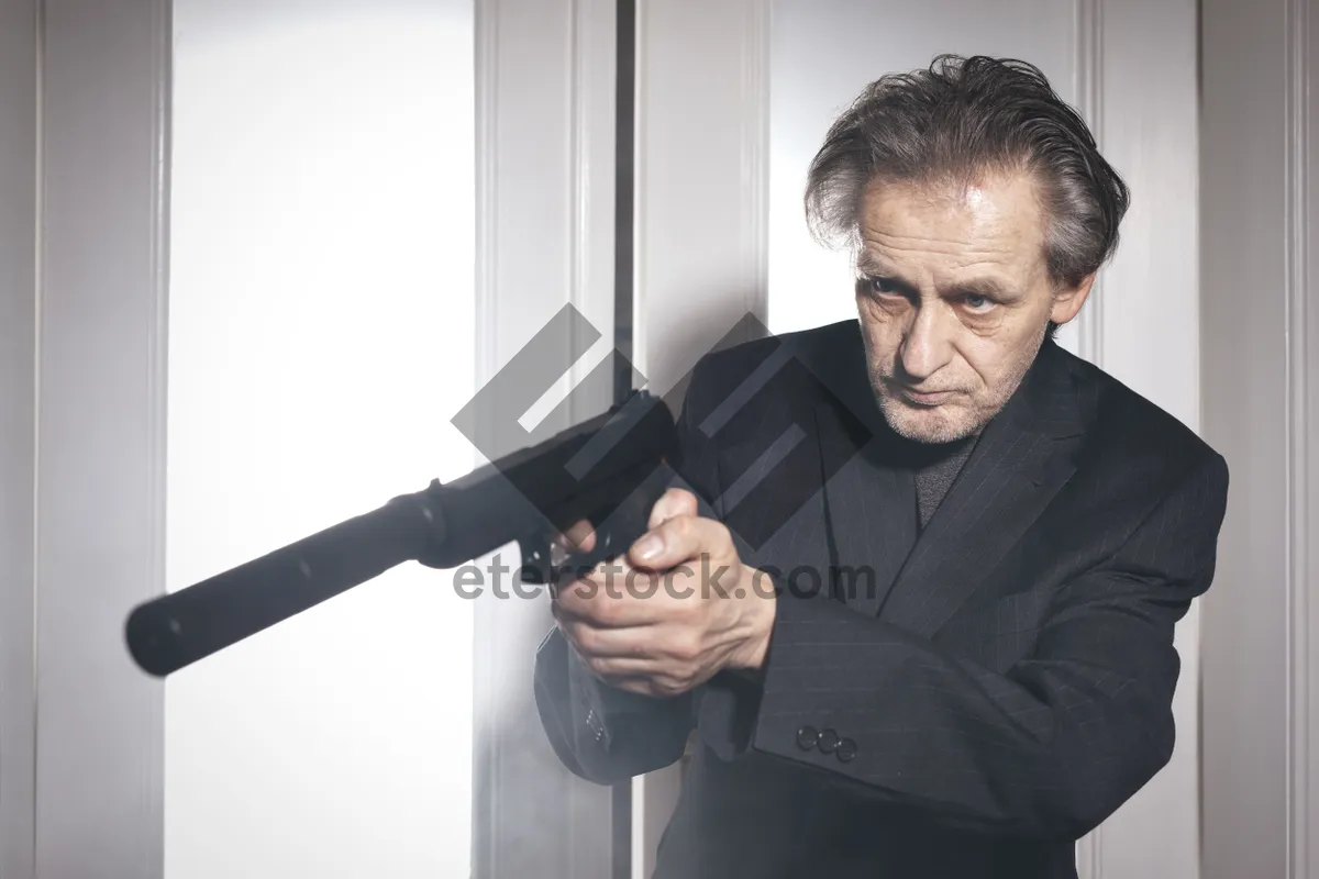 Picture of Professional businessman holding microphone and gun in suit portrait.