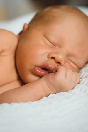 Adorable Baby Boy Smiling in Mother's Arms.