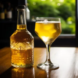 Yellow wine bottle and glasses for celebratory party setting.