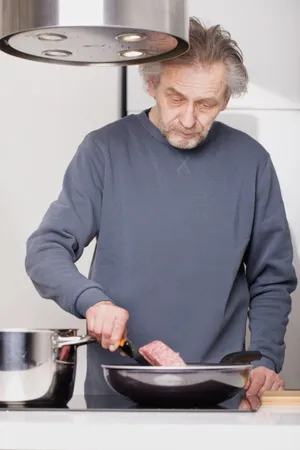 Happy Senior Man Smiling at Computer at Home